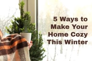 hands covered by blanket in front of window holding mug with text 5 Ways to Make Your Home Cozy This Winter